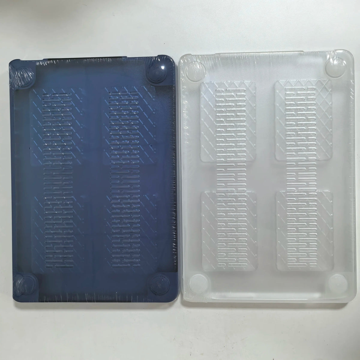 Two translucent hard shell laptop cases, one blue and one clear, showing textured grips.