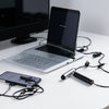 A laptop and a multi-color fine point stylus are displayed on a white desk.