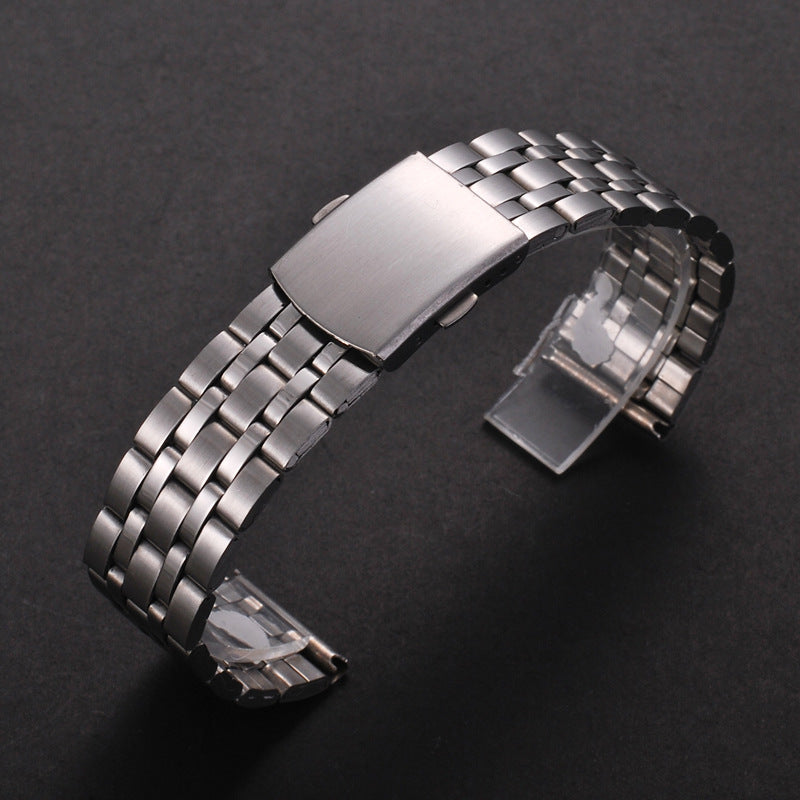 A stainless steel watch band with a folding safety clasp shown on a dark background.