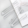 A set of precision folding transparent rulers and measuring tools laid out on a white background.
