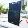 A black LCD writing tablet displaying handwritten text on a white desk next to a potted plant.