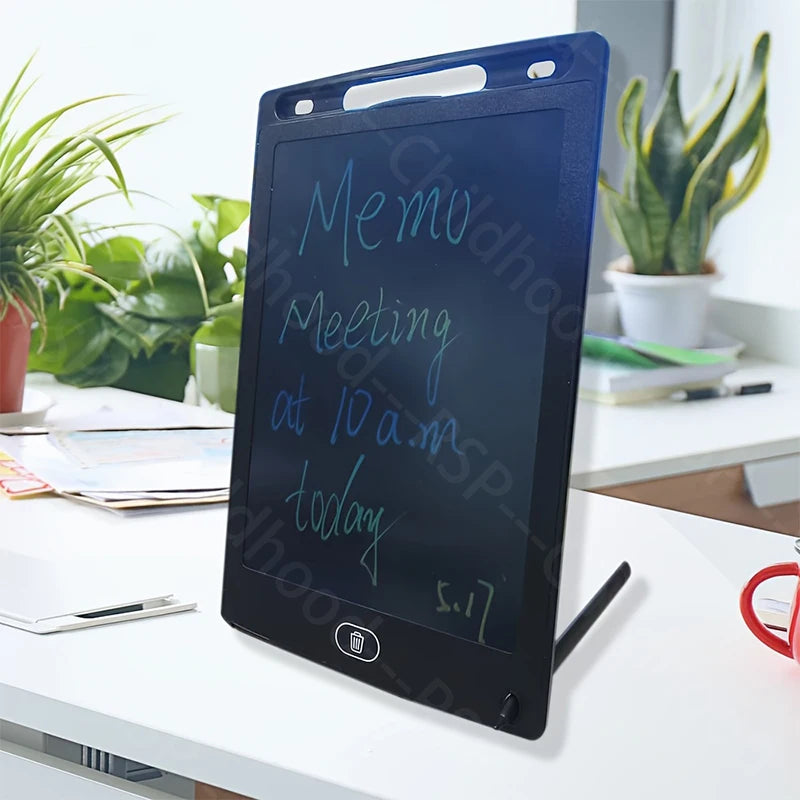 A black LCD writing tablet displaying handwritten text on a white desk next to a potted plant.