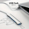 A white USB hub with four ports and an OTG adapter is shown connected to a laptop.