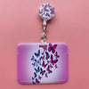 A purple card holder clip featuring a pink butterfly design and a white clip on a pink background.