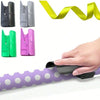 A hand is shown using a portable plastic wrapping paper cutter on purple patterned paper.