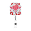 A pink anatomical heart shaped charm with the text At Your Cervix on a silver acrylic necklace.