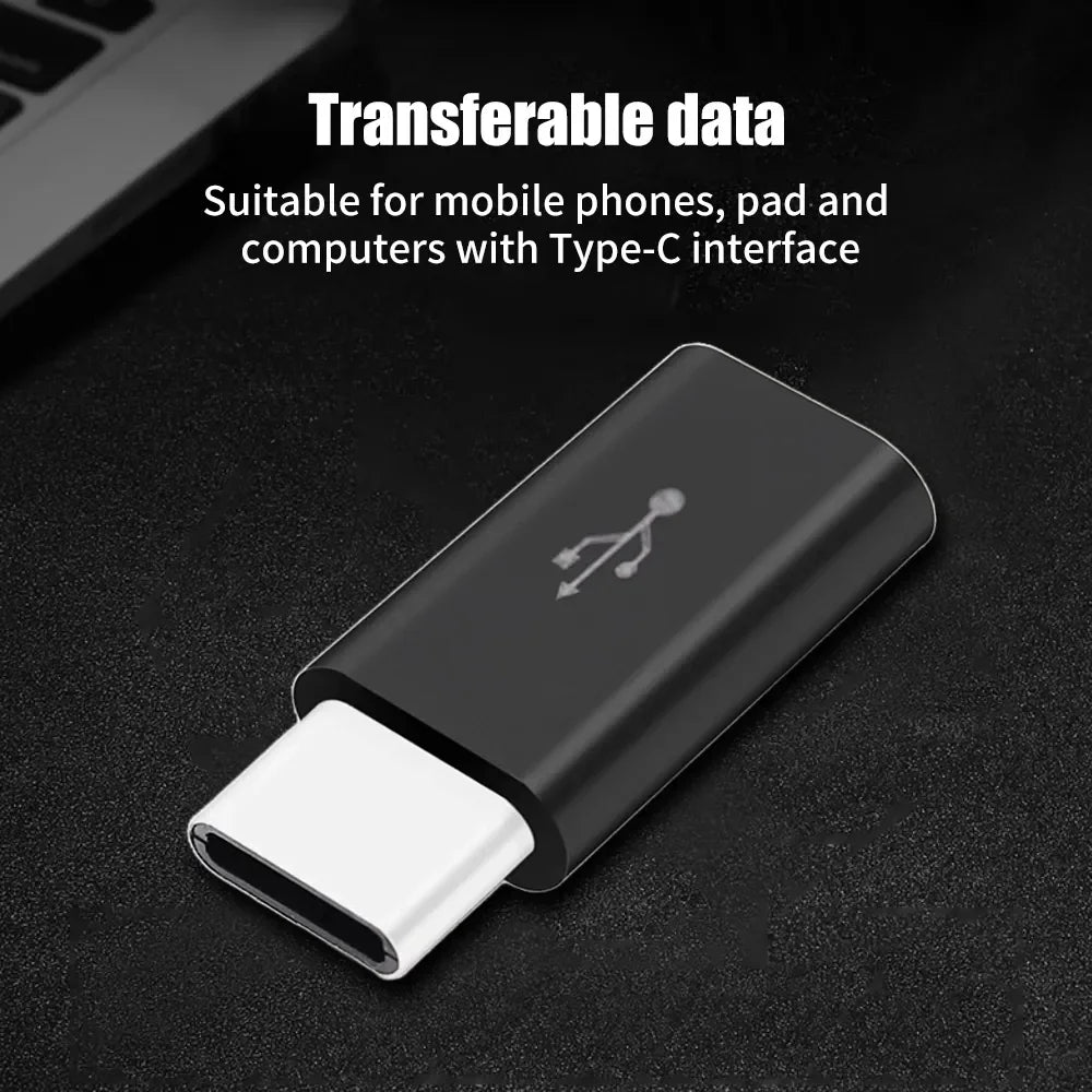 A black USB Type-C to Micro USB adapter converter lying on a dark surface.