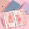 A pink reusable envelope binder with a clear plastic sleeve showing pink and orange watercolor designs.