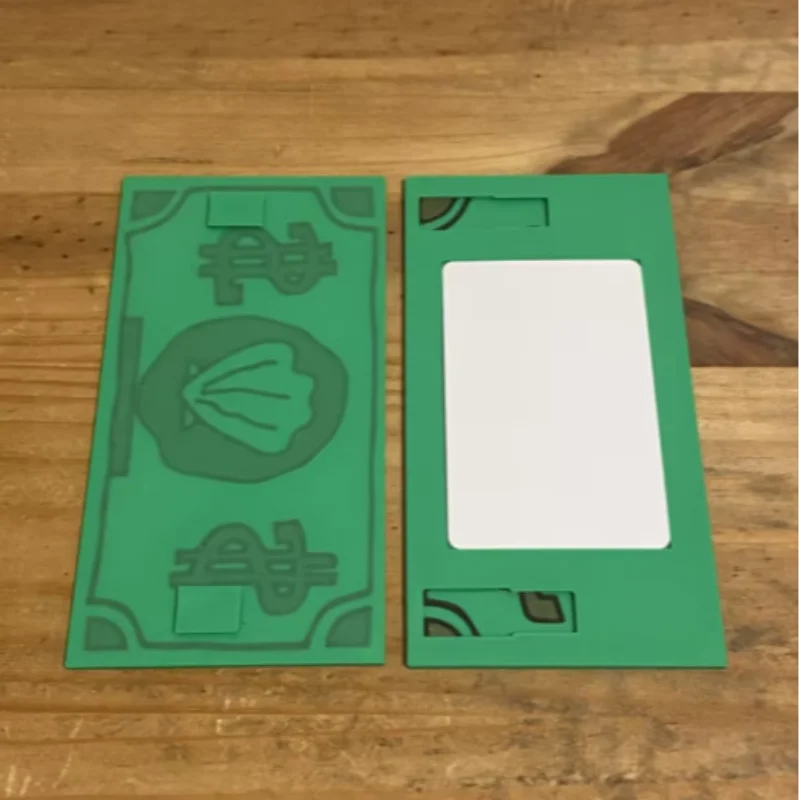 A green 3D printed shell card holder with an NFC tap-to-pay feature lying on a wooden surface.