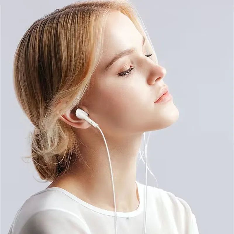 A woman is shown wearing white HiFi Wired Earbuds with a microphone.