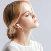 A woman is shown wearing white HiFi Wired Earbuds with a microphone.