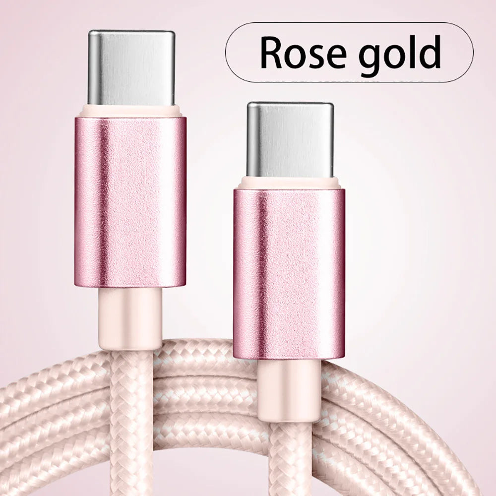 A close-up of a rose gold USB-C to Type-C charging cable with metallic connectors and braided wire.