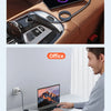 A magnetic suction charging cable is shown resting on a leather seat, next to an office laptop.