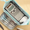 A light blue canvas pencil case is open, showing a Canon calculator and various pens and pencils inside.