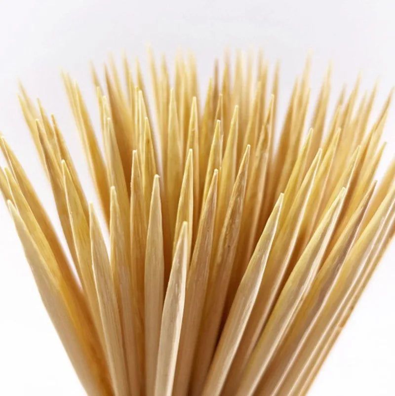 A close-up view of a set of natural bamboo skewers with various lengths.