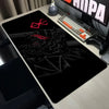 A black gaming desk mat featuring a red Berserk anime logo and intricate dark texture, placed next to a mechanical keyboard.