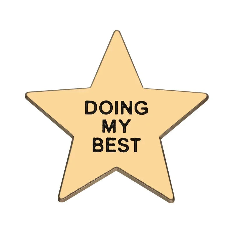 A gold star-shaped enamel pin with the text Doing My Best engraved on it.