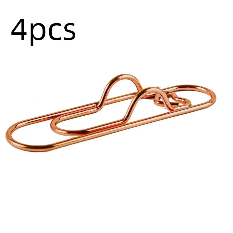 Four copper-colored magnetic pen clips or page markers.