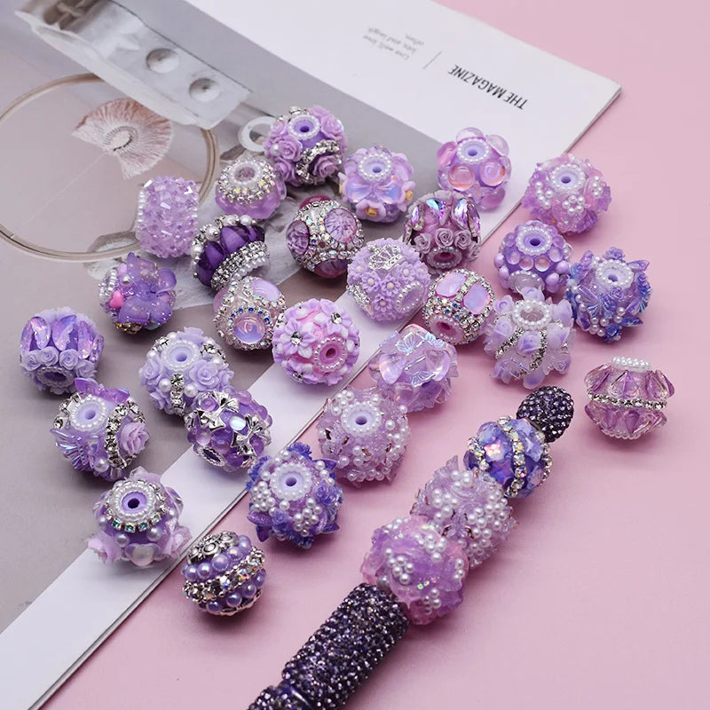 A collection of purple and lilac handmade acrylic flower beads for jewelry making displayed on a white card.