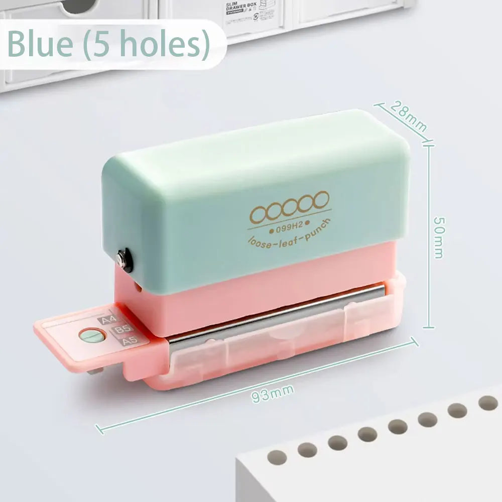 A light green mini multi-hole punch with a pink casing and silver punch, shown next to a stack of paper.