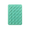 A green silicone suction cup tray containing twenty-four individual suction cups for mounting phones and tablets.