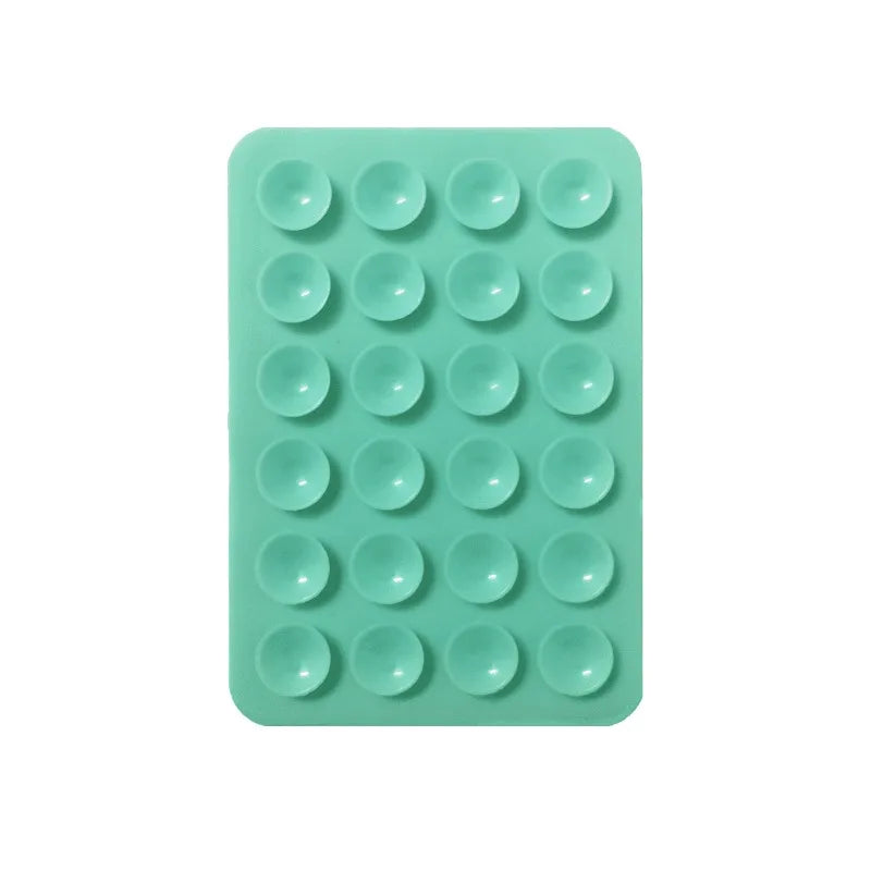 A green silicone suction cup tray containing twenty-four individual suction cups for mounting phones and tablets.