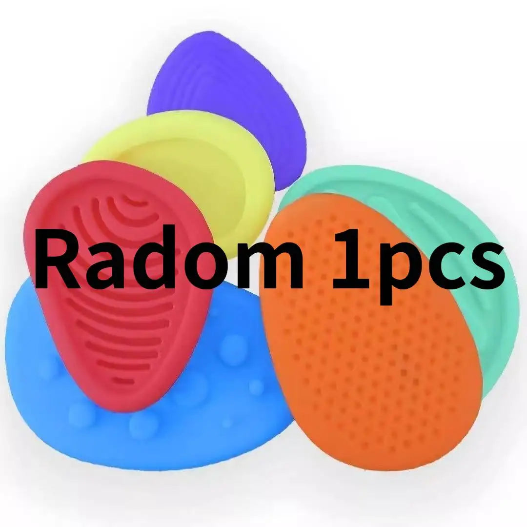 A collection of five colorful sensory stones or fidget toys in various shades including purple, yellow, red, blue, and orange