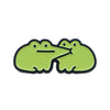 A pair of lime green enamel pins shaped like smiling frogs.