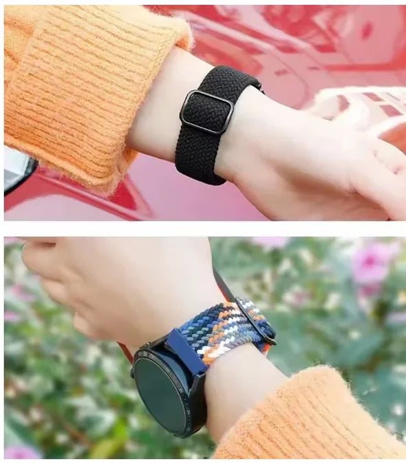 A close-up of a black braided loop watch band worn on a wrist next to an orange knitted sleeve.