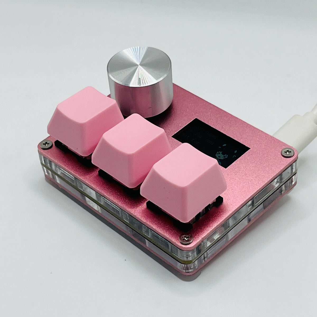 A close-up view of pink magnetic rapid trigger keyboard switches with silver top caps and a black switch visible.