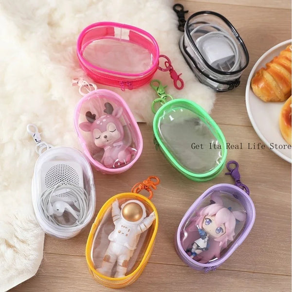A collection of mini clear bags and pink/green keychains displayed on a wooden surface.