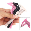 A hand holds a pink and black precision eyebrow measuring caliper with a ruler scale.