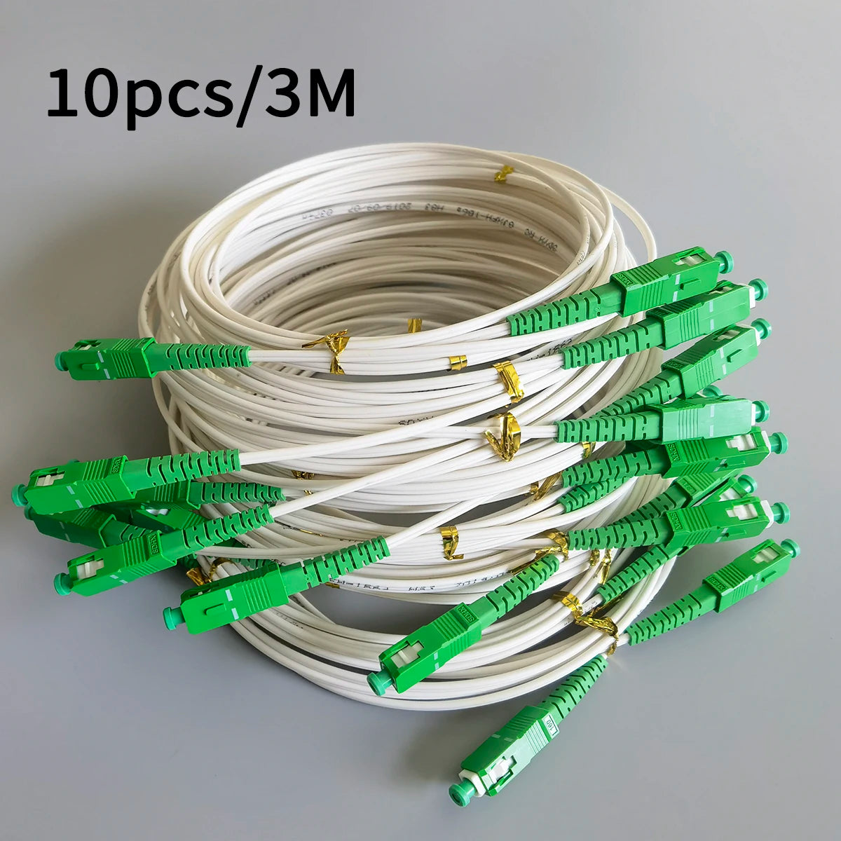 Ten pieces of white single-mode fiber optic cable with green connectors coiled together.