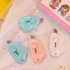 Three small plastic cat paw mini cutters in light blue, pink, and white are displayed on a pink fabric.