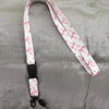 White lanyard with pink floral print and black clip attached