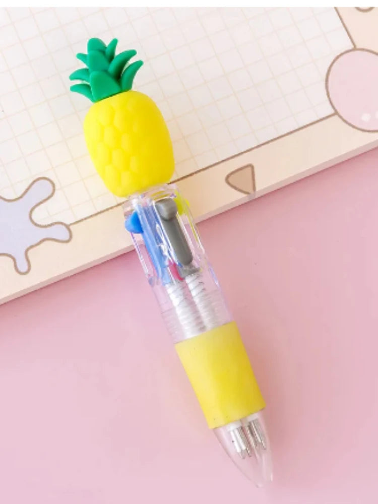 A yellow pineapple shaped pen with a green top and a yellow body, resting on a pink surface.