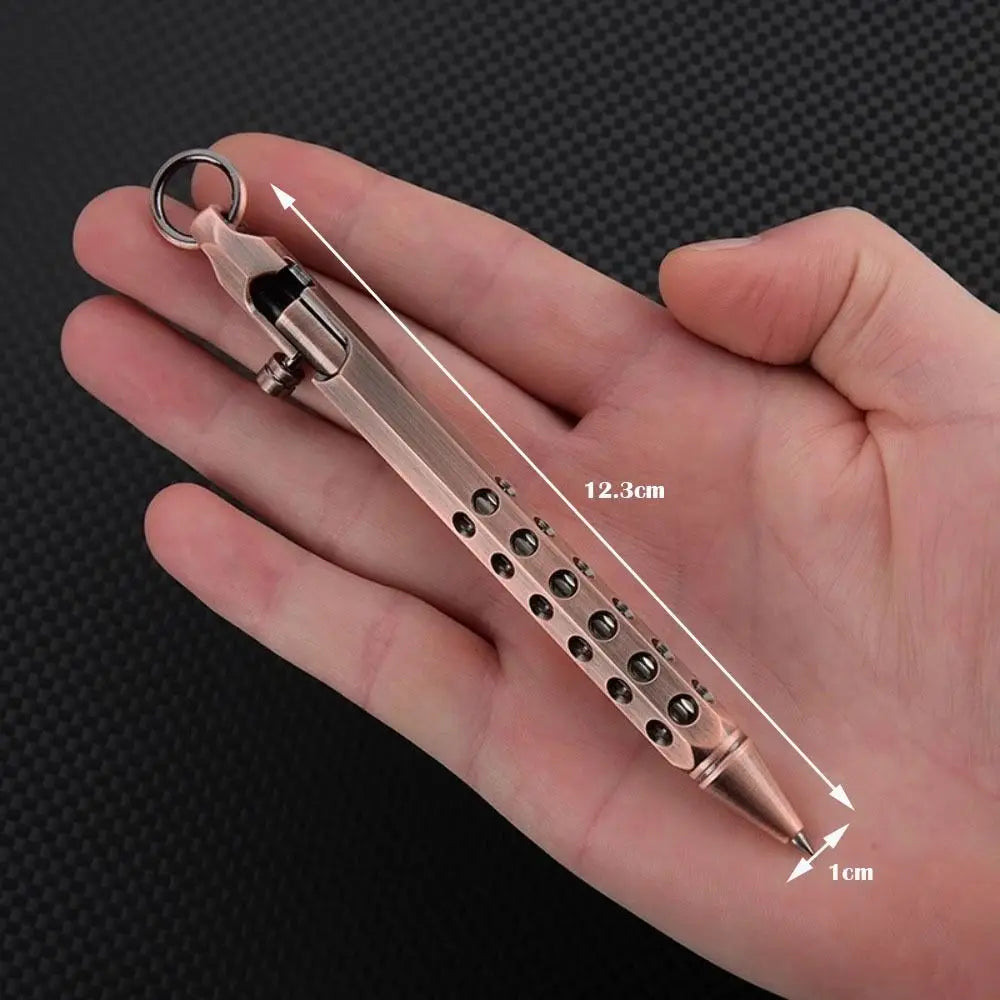 A hand holds a brass bolt-action ballpoint pen with a metal clip and a pointed tip, showing its length.