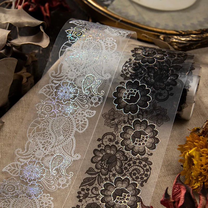 Clear decorative silver stamping lace tape featuring intricate floral patterns on a beige fabric background.