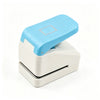A light blue embossing punch machine with a white base and a square embossing plate.