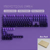 Vista cercana de un teclado mecánico morado con teclas dobles y retroiluminación RGB.
