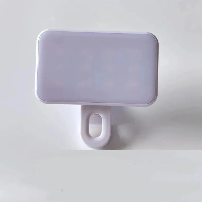 A white rectangular portable rechargeable mini selfie light with a loop for attachment.