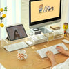 Acrylic keyboard stand holding a white keyboard and mouse on a wooden desk with a computer monitor in the background