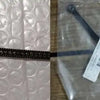 A precision ring sizer and gauge tool is shown next to a black strap on a pink textured fabric.