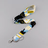 A yellow and black patterned cat print lanyard with a metal clip and card holder.