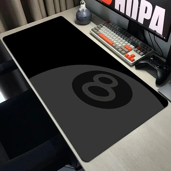 A black No.8 billiards ball large mouse pad is displayed on a desk next to a keyboard and a decorative object.