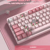 A close-up of a pink mechanical keyboard featuring durable double-shot PBT keycaps and RGB lighting.