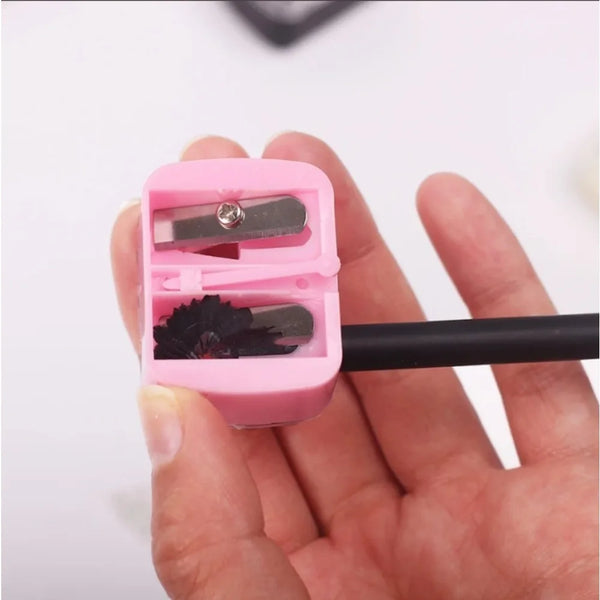 Rosa automatische Doppelhole-Bleistift-Schärfer mit schwarzem Griff wird in einer Hand gehalten.
