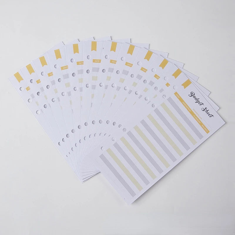 A stack of A6 budget sheets with envelope pockets and expense sheets in yellow and gray tones.