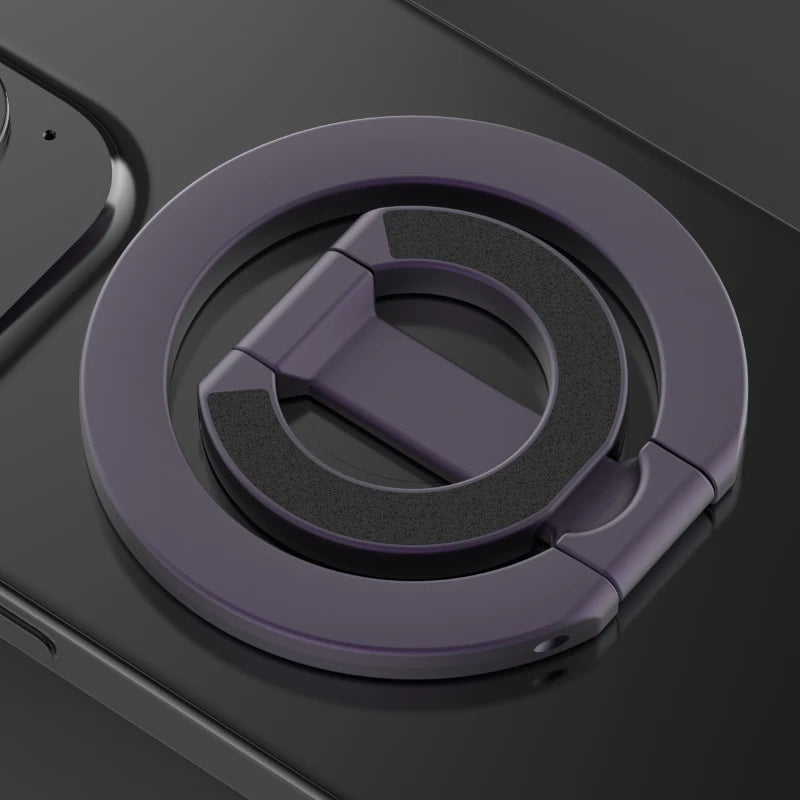 A close-up view of a purple MagSafe double-sided phone ring holder on a dark surface.