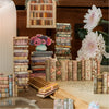 A collection of vintage and modern books, including relief art and gallery stickers, arranged on a wooden surface.